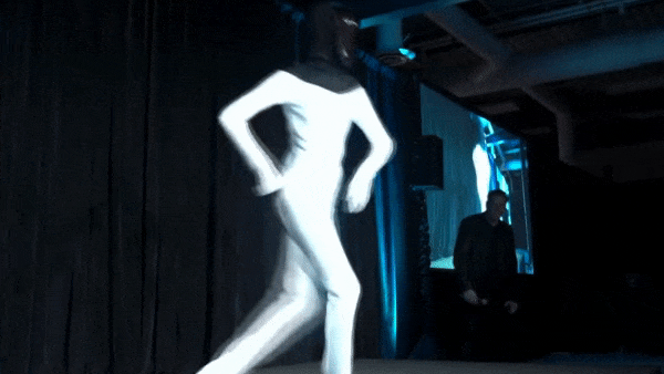 Person dressed up as Tesla Bot showing some dance moves 