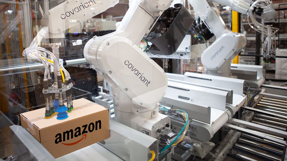 Covariant robotic arm clutching an Amazon box.